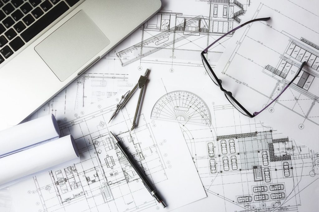 CAD drawings next to a laptop