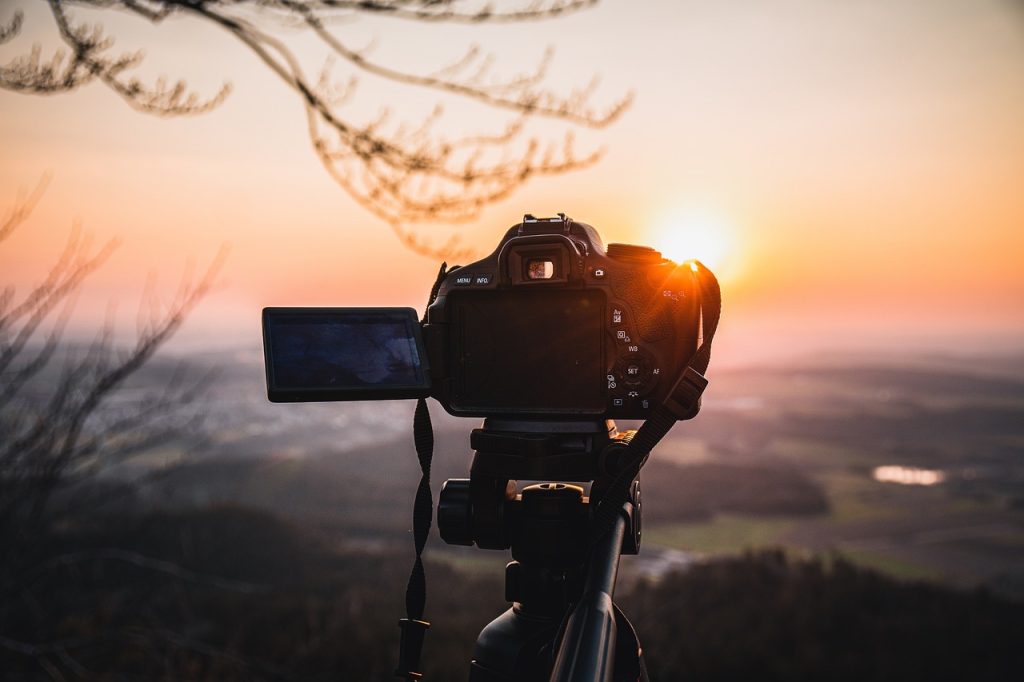 Camera on tripod taking photo of landscape